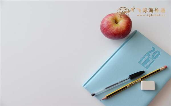 一本书旁边有笔和苹果